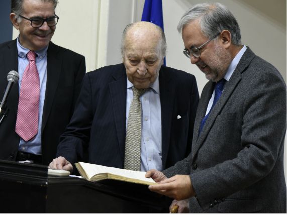 Doctores Mario Pardo, Carlos Gómez y Manuel Kukuljan revisan uno de los libros franceses donados por el doctor Gómez. 
