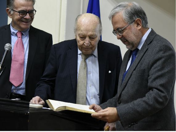 Doctores Mario Pardo, Carlos Gómez y Manuel Kukuljan revisan uno de los libros franceses donados por el doctor Gómez.